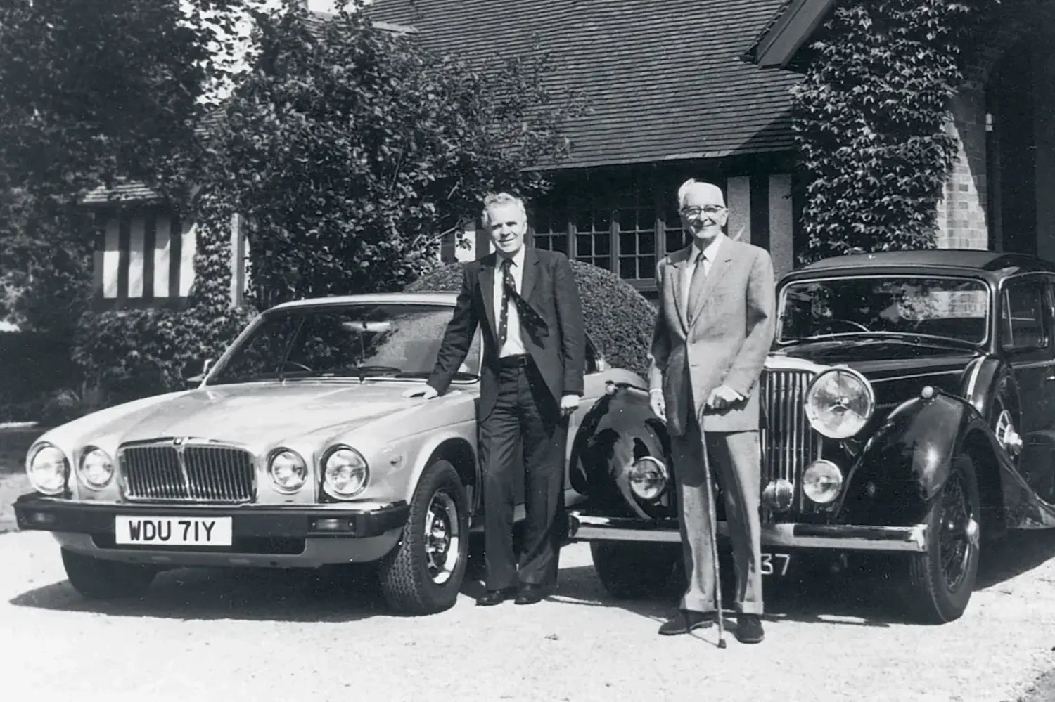 Sir William Lyons with John Egan at Wappenbury Hall, near Leamington Spa, pictured alongside a Jaguar XJ Series III and an SS1